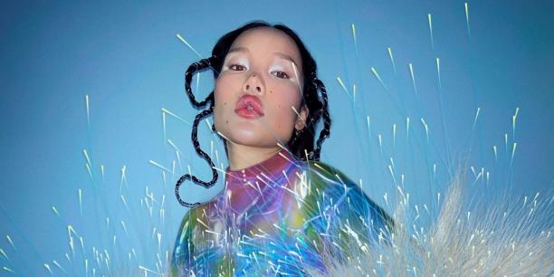 Aziatisch meisje met veel makeup tegen lichtblauwe achtergrond 