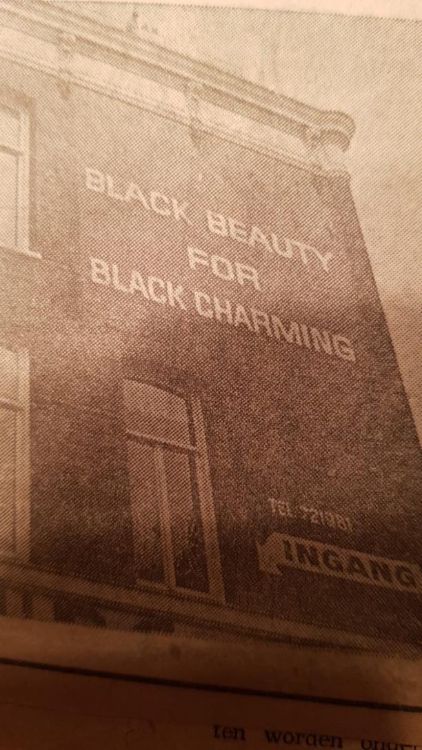 teksten 'black beauty for black charming' op de voorgevel van pand